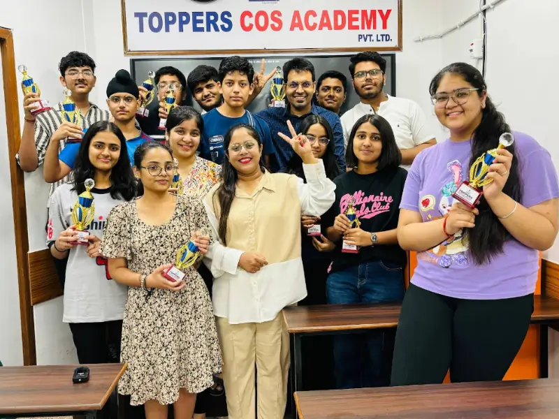 Group of successful students holding trophies with faculty members