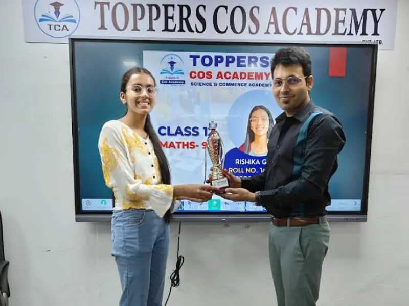 Rishika Gupta Class 12 topper scoring 97 marks in Maths receiving award at Toppers Cos Academy
